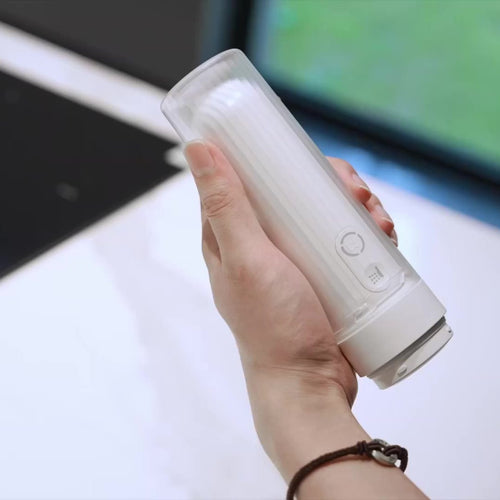 GoWash electric travel bidet held in hand – real photo of the unit (nozzle stowed under the clear cover)